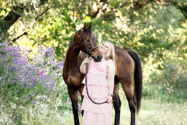 high school senior equestrian photographed wearing a dress with her bay horse in the flower garden in Madison, wisconsin photographer near me