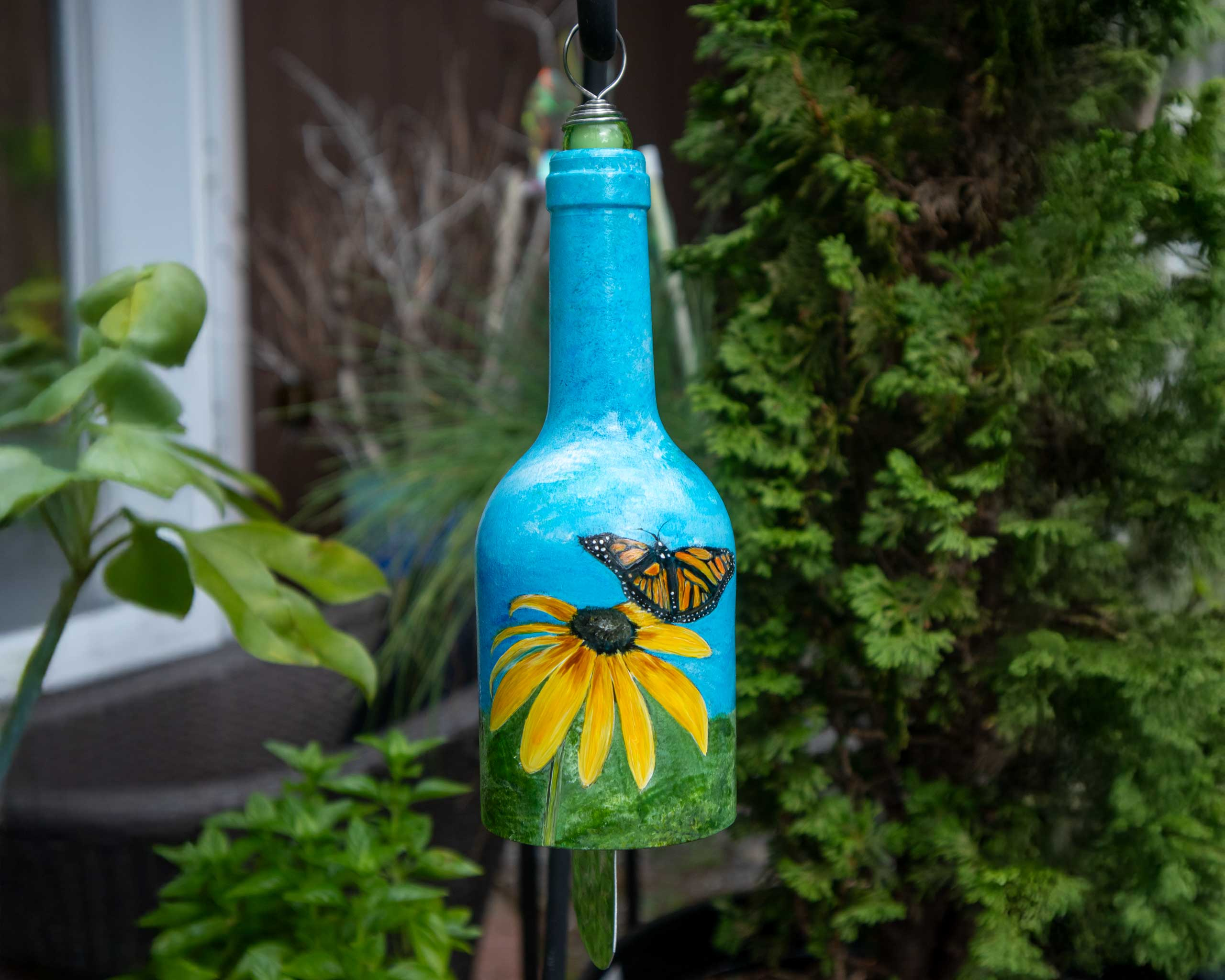 Hand painted recycled glass wind chime hanging outdoors