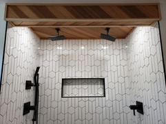 White Chevron and Hexagon Tile Shower with Black Fixtures.jpeg