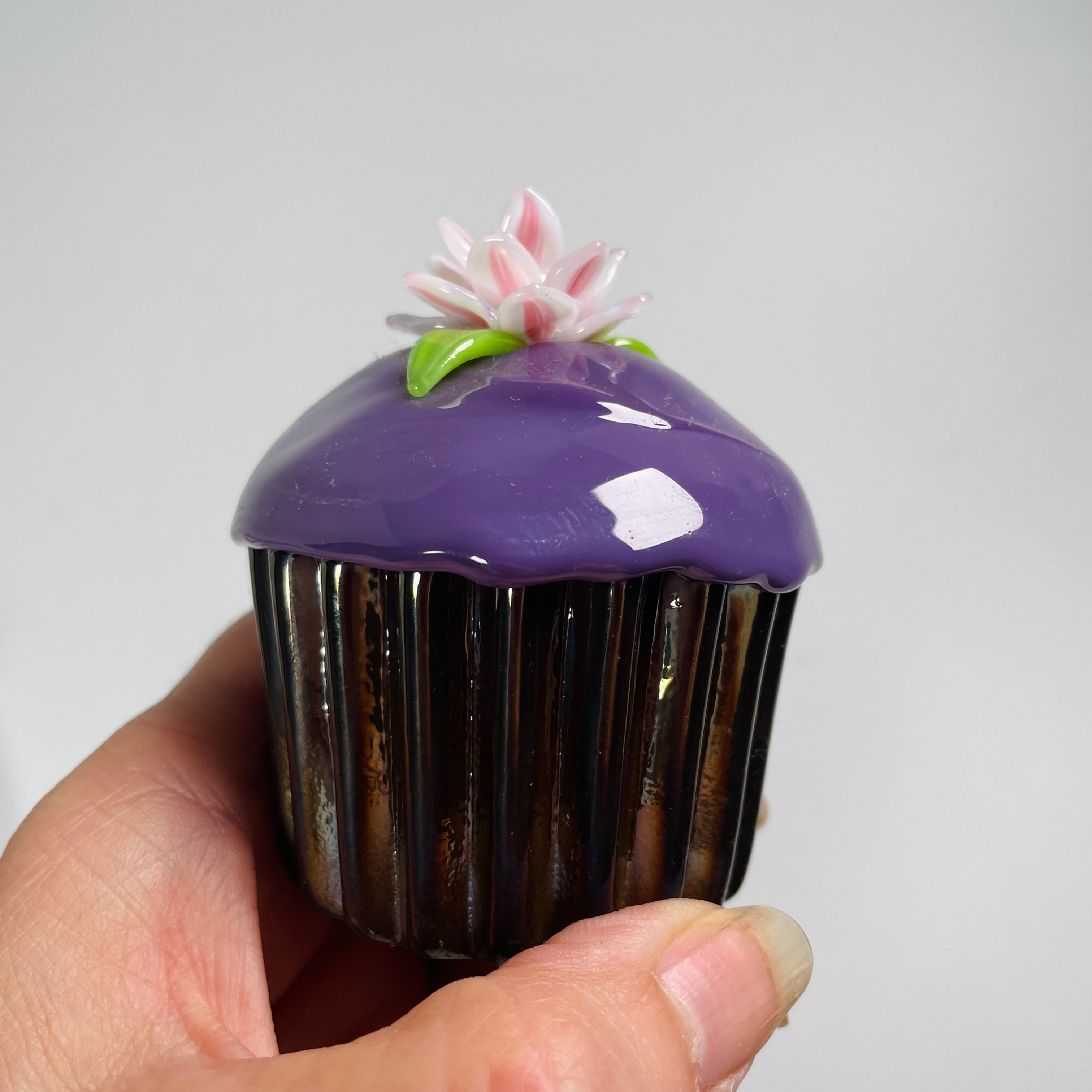 Purple frosted cupcake with a single flower