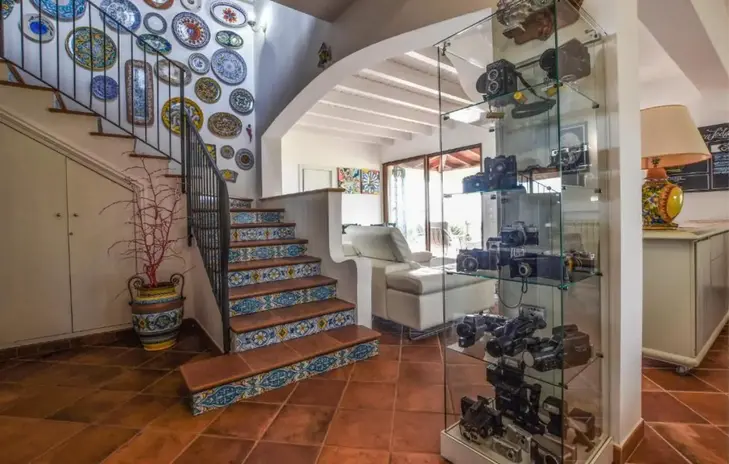 Scale interne decorate, espositore macchine fotografiche, luminoso ingresso Villa Musa.