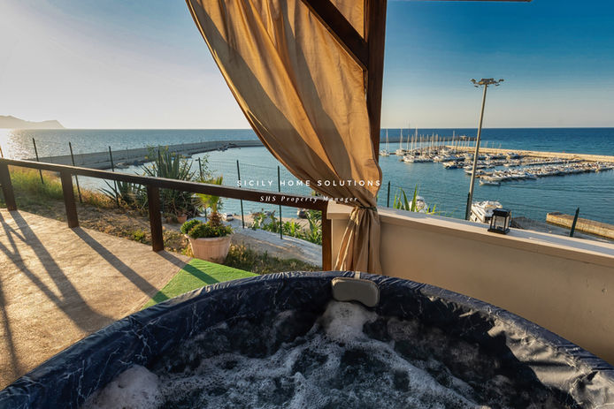 Vasca idromassaggio con vista mare e testo