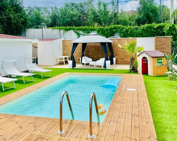 Piscina esterna, gazebo, deck in legno, prato verde. Ville di lusso in Sicilia.