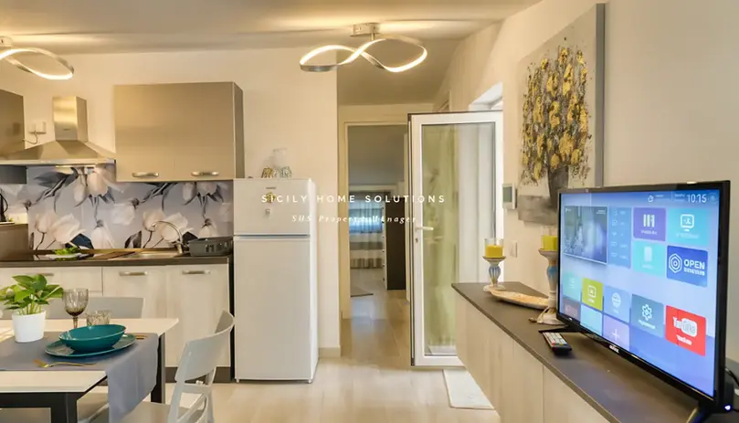 SICILIAN HOME SOLUTIONS REAL ESTATE AGENCY: cucina moderna open space con soggiorno e TV.