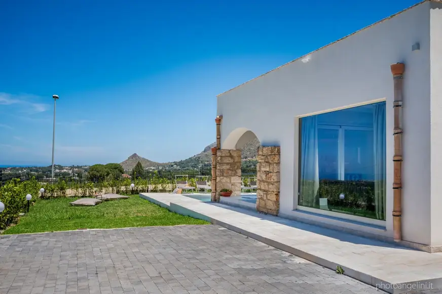  villa Castellammare del golfo con piscina con ampie finestre e vista mare, cielo azzurro.