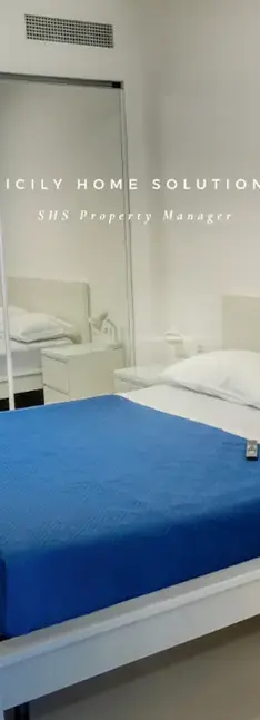 Camera da letto moderna con letto blu. SICILY HOME SOLUTIONS PREMIER Property Management.