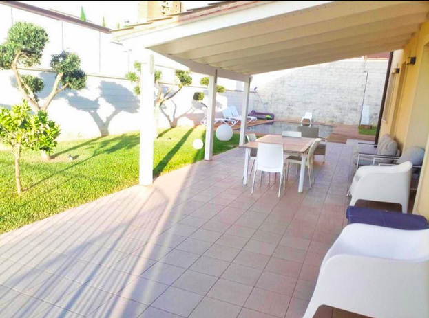 Patio esterno con piscina e mobili da giardino
