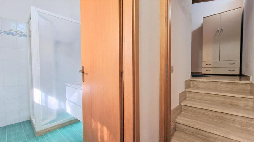 Porta di legno aperta, bagno bianco e scala, ville deluxe con piscina.