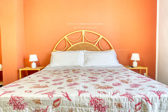 Letto matrimoniale con cuscini e lampade. Testo visibile, ville deluxe