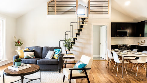 Foto sala de estar com poltronas, escada e mesa de jantar