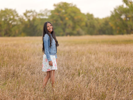 High School Senior in a field in Lakewood, posing for her Senior Photos, by Lily & Aspen Photography.