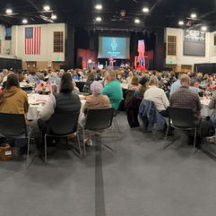 A wide panoramic image of tables of people during a national day of prayer held in Holland, MI
