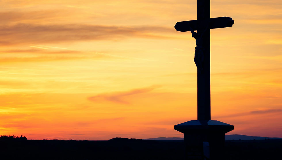 Jesus on a cross with the sun setting in the background.