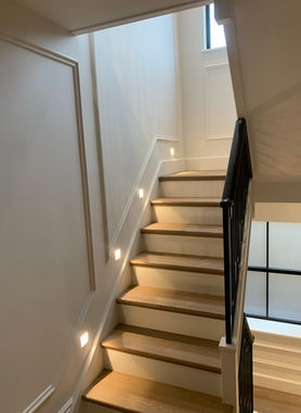 Modern wooden staircase with wall step lighting