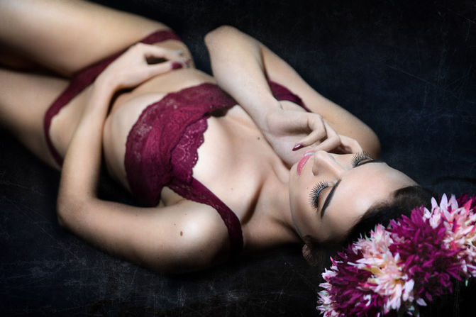 Glamour snímek ženy na černém pozadí, červený outfit a uvolněná póza, foceno v Boršicích.