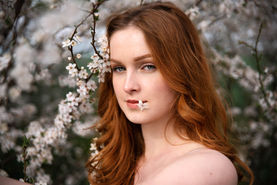 dívka s květem mezi rty, jarní portrét, rusovláska v přírodě