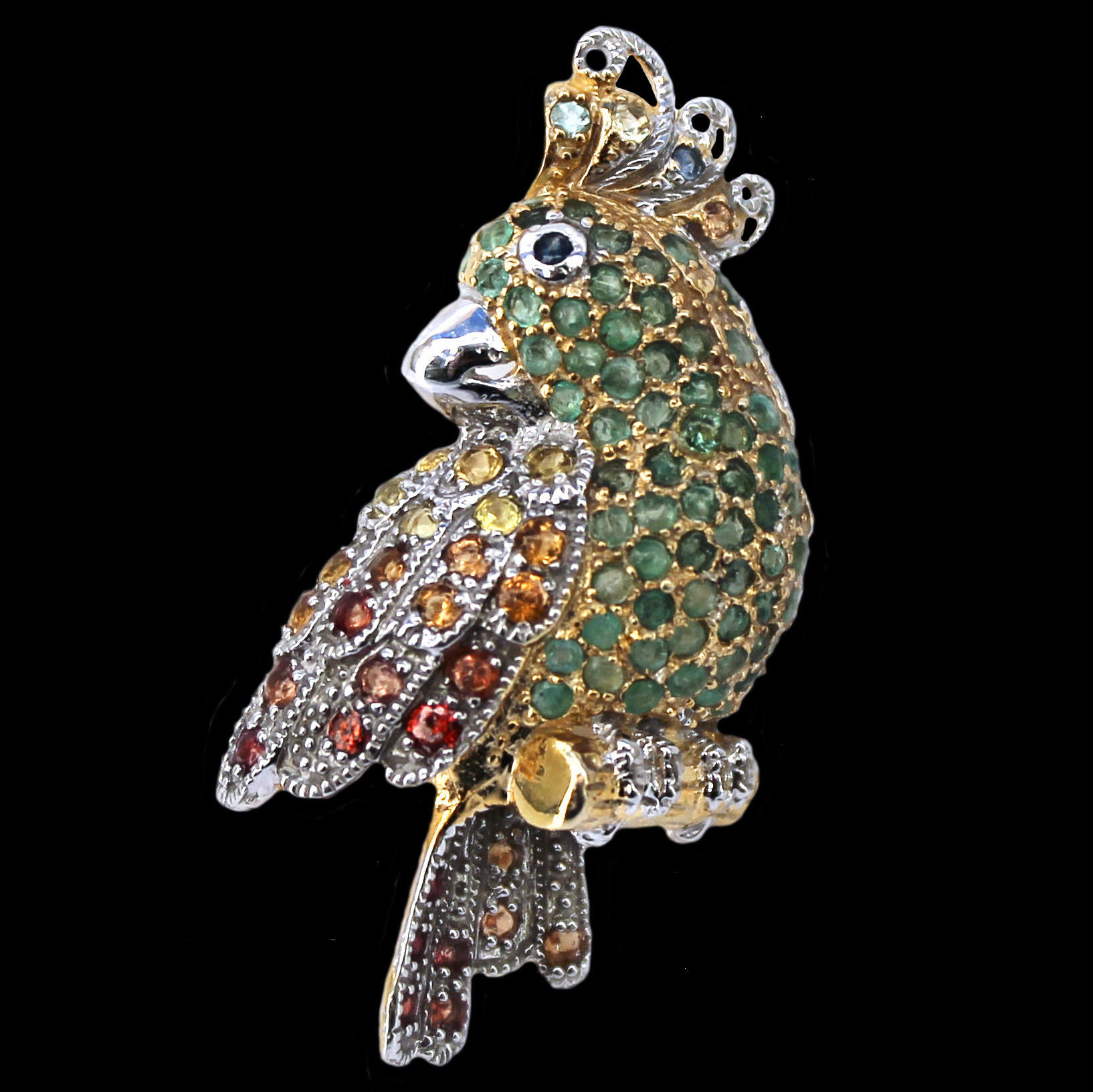 Spilla a forma di pappagallo con smeraldi e zaffiri in argento dorato