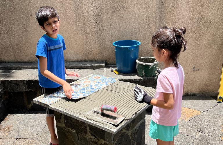 Les enfants aident à poser les carreaux