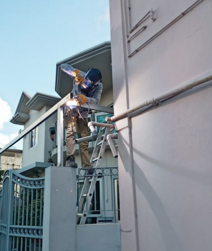 Handyman on Ladder, Welding Galvanized Metal Tube Support