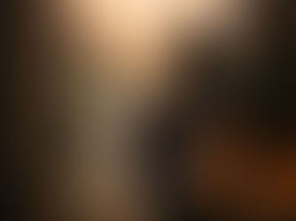 A woman sitting on a stone threshold at sunrise, looking out at a winding path and representing the release of the myth of being behind through somatic healing and nervous system rest.