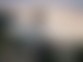 A serene coastal scene at twilight, showing a woman in a knit sweater, viewed from behind, setting down a heavy wicker basket full of stones on a large grey boulder. This visual represents the somatic and soul-led act of 'choosing your peace' by releasing a burden that was never yours to carry.