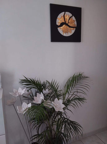 Décoration murale : tableau rond or et noir, et fleurs en céramiques