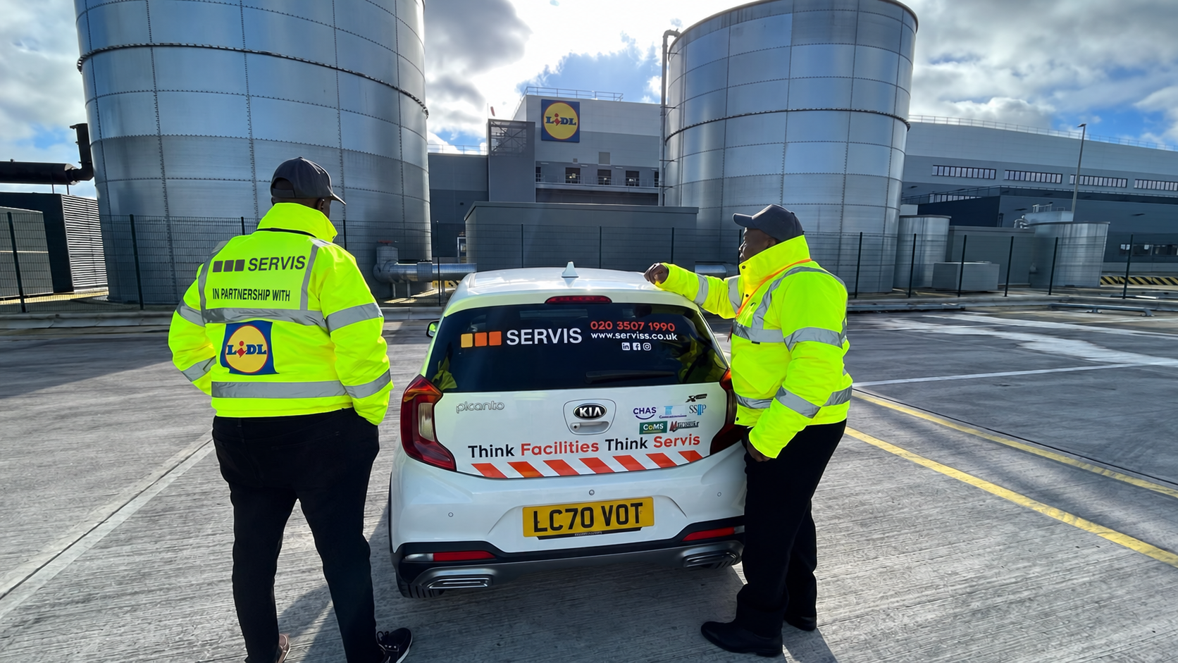 Servis security colleagues beside a company vehicle
