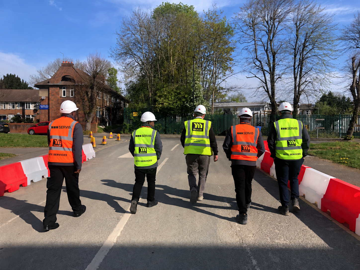 Servis colleagues walking together on a construction site, with updated three-square uniform branding