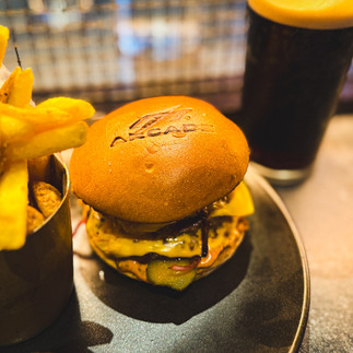 Burger and fries served at F1 Arcade London with the F1 Arcade logo branded into the bun