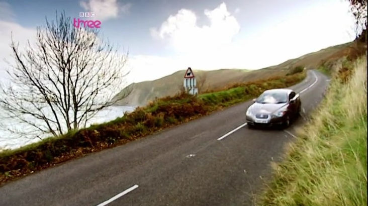 Top Gear Series 10 Episode 10 - James is driving new Jaguar XF along a coastal road atop a large cliff demonstrating the handling ability of the vehicle.