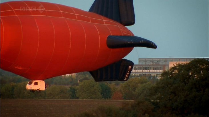 Top Gear Series 14 Episode 3 - James flying hist caravan airship as the sun is setting is slowing losing altitude above a farmers field in Cambourne, England.
