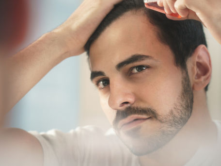 Hombre joven cuidando de su cabello.