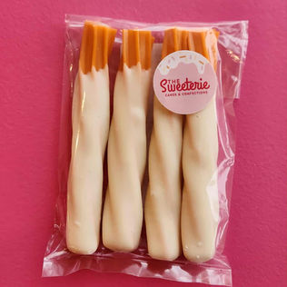 Packaged white chocolate pretzels with orange tops, 'The Sweetarie Cakes & Chocolates'.