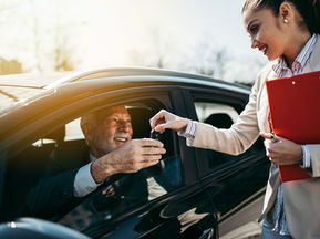 A man buying a used car from a woman