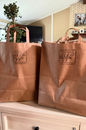 A brown paper bag stamped with the Weise Farms logo — packed with a handpicked surprise selection of farm fresh Wagyu beef and homemade extras from Weise Farms in Serbin, Texas.