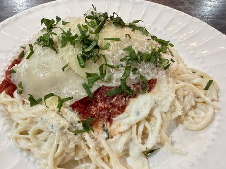 Wagyu beef Parmesan topped with marinara, melted mozzarella, grated Parmesan, and fresh basil, served over homemade angel hair pasta in Alfredo sauce at Weise Farms.