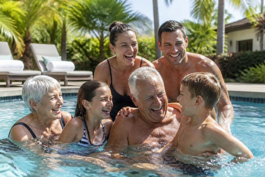 Multi-generational family laughing while swimming in a Sarasota vacation rentals with pools heated pool.