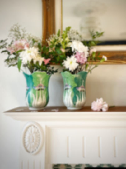 Pair of Chinese Pak Choi Butterfly Vases with flowers on a mantel piece