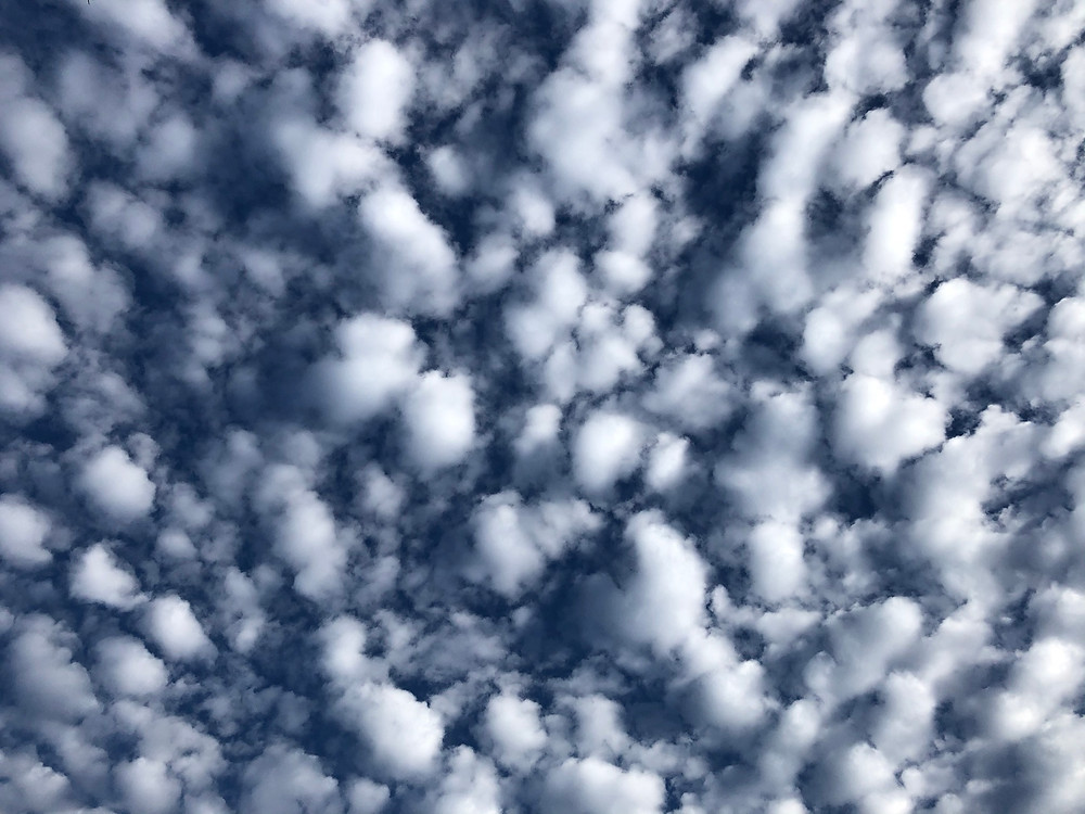 small puffy clouds in dark blue sky