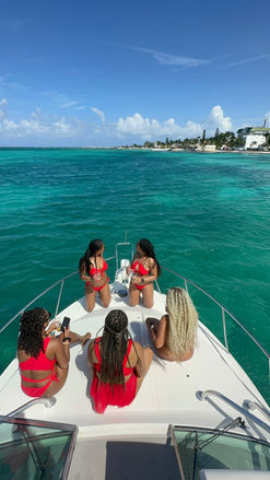 A group of four girls on a yacht, sharing smiles and laughter while enjoying a day at sea.