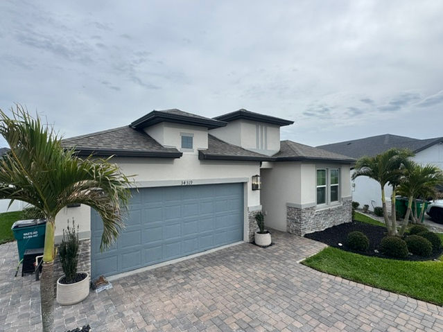House at 14319 with a blue garage door and palm trees.


