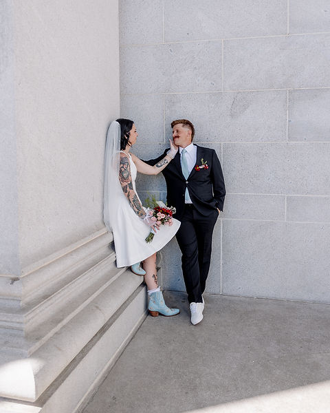 A bride and groom pose at the Denver courthouse.