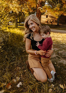 A mother holds and cozies up with her son.