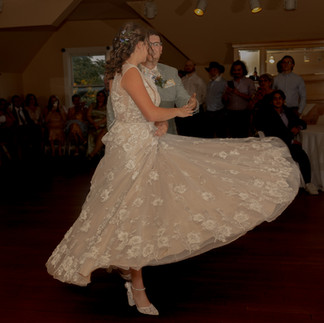 A brides dress flares out during the first dance with her groom.