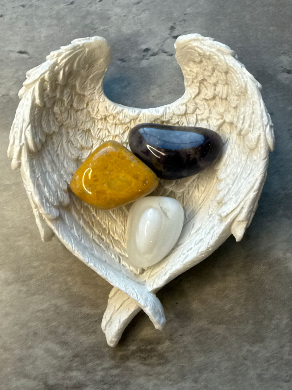 amethyst, yellow jade and magnesite sitting in an angel wing bowl