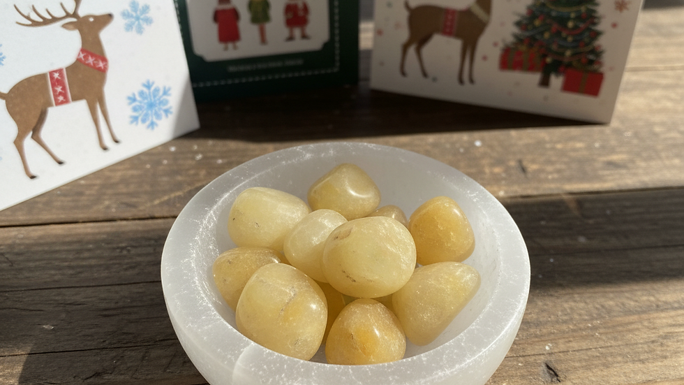 Yellow Jade crystal placed in a selenite bowl with Christmas cards in the background