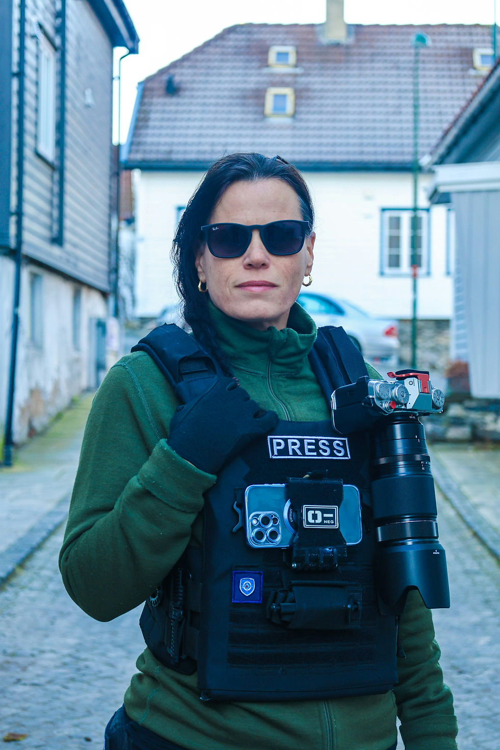 Photojournalist holding a professional camera while working in the field.