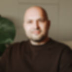 Bald man with beard, dark shirt, smiling