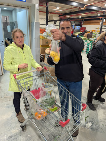 Man holding a bag of lemons, woman with a grocery cart