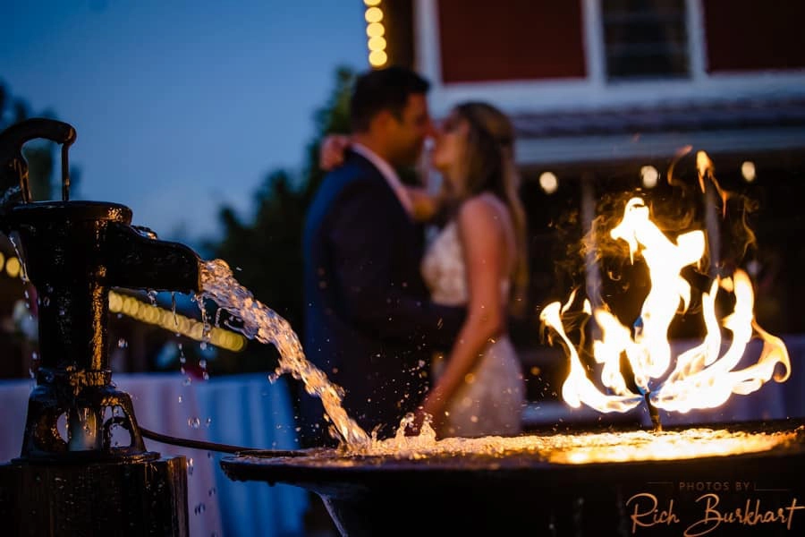 the fire and water fountain incorporated into wedding portraits taken in the brick courtyard of the Barn at Red Gate Farms